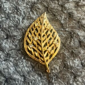 Golden rhinestone vintage pin shape of a leaf